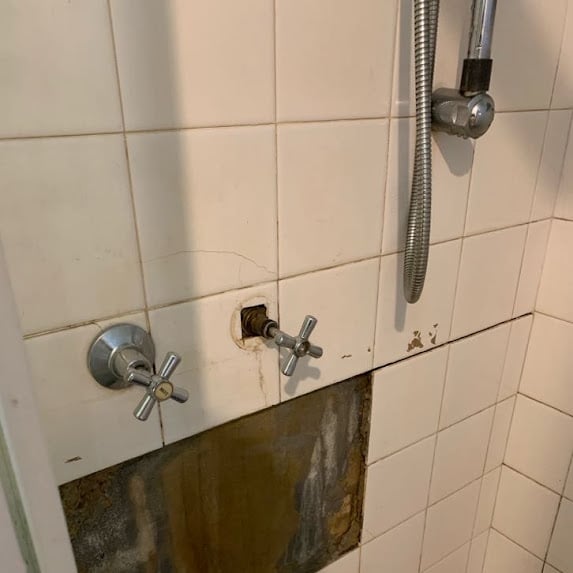 Shower wall opened to access a burst water pipe in Glen Iris