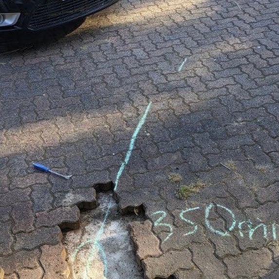 Leak detection marking on a paved driveway showing the location of a hidden water leak in Burwood