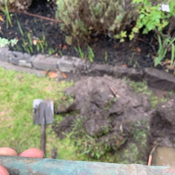 Excavated front garden showing underground water pipework during repair in Camberwell.