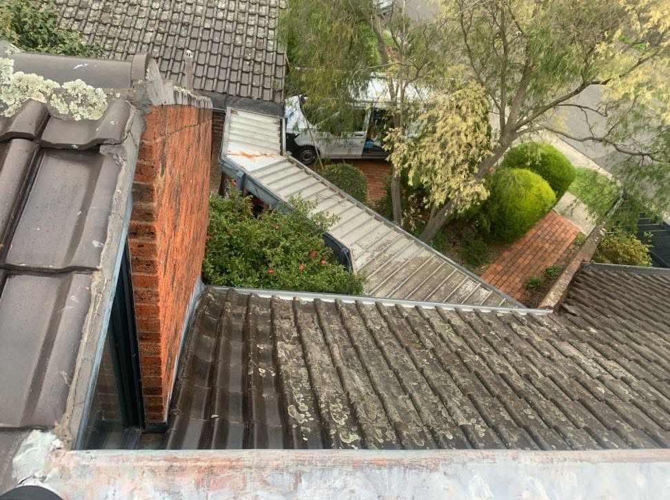 Wide view of tiled roof and adjoining metal roof section during repairs in Burwood.