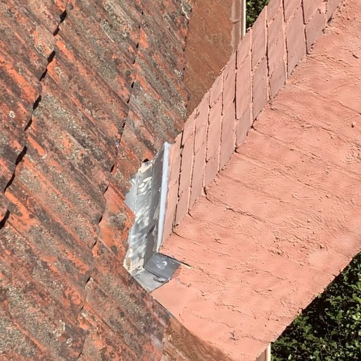New metal chimney flashing installed on a terracotta tiled roof in Glen Iris.