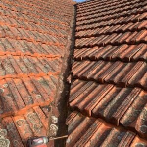 Roof plumber working on a valley of a terracotta tiled roof in Glen Iris.