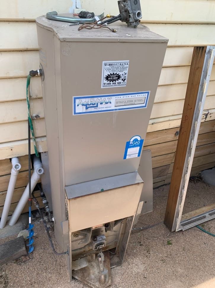 Old AquaMAX gas hot water system before replacement at a Burwood property.