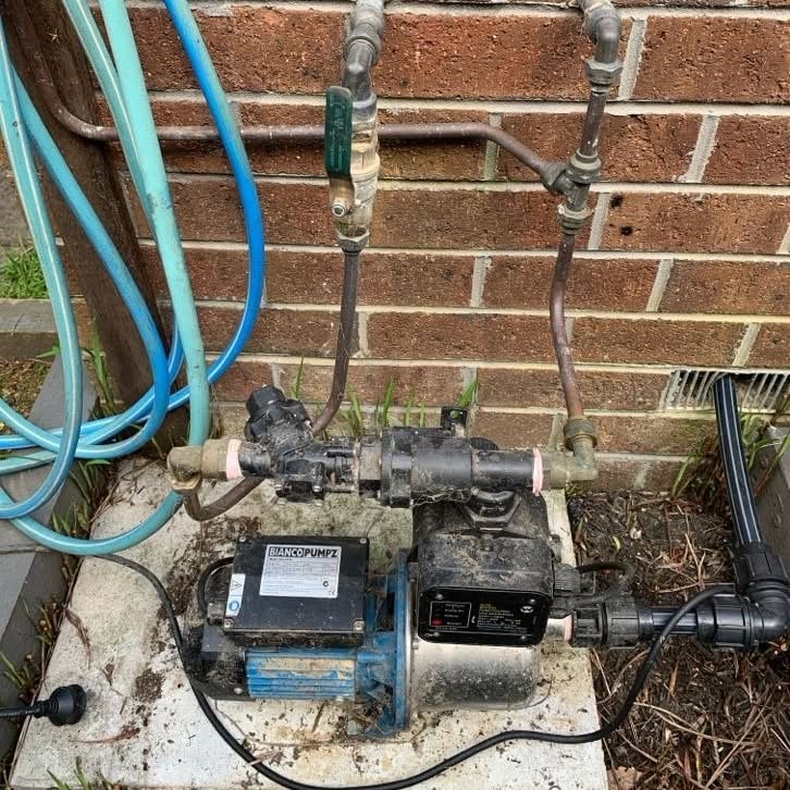 Faulty rainwater tank pump on a concrete pad at a Burwood property.