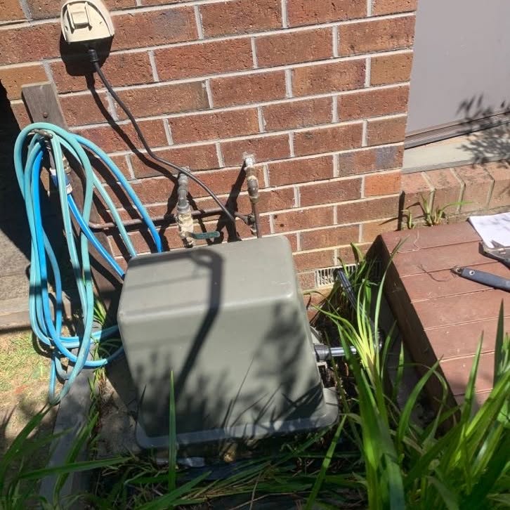 Protective cover lid installed over a rainwater tank pump in Burwood.